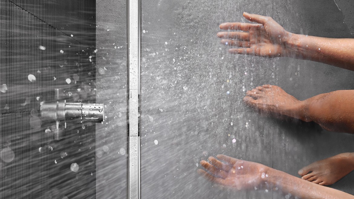 Persona duchándose en una ducha a ras de suelo con canal de ducha Geberit CleanLine