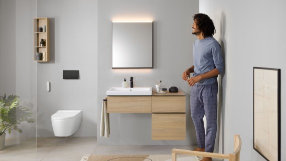 Hombre en un baño con Geberit AquaClean Sela