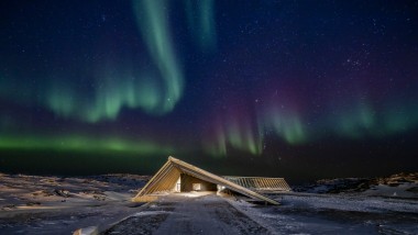 El Icefjord Centre bajo la espectacular aurora boreal de la noche polar groenlandesa (© Adam Mørk)